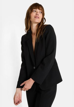 Blazer negro entallado con solapa de muesca, cierre de un solo botón y ligero acolchado en los hombros. Tejido suave con una silueta estructurada.