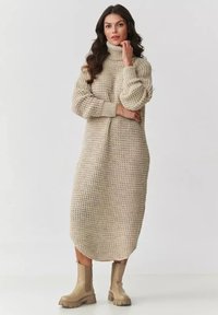 Beżowa, dziana sukienka golfowa o luźnym kroju, z prążkowanymi mankietami i teksturowanym, grubym splotem, z zaokrąglonym dołem.