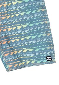 Shorts de bain dans un motif de vagues bleu et vert, avec des accents orange. Présente des coutures piquées et un petit patch logo noir.