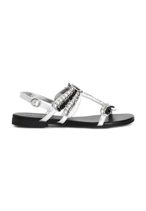 Sandali piatti argento con accenti di perline, caratterizzati da un design a T, adornati con perline nere e a forma di perla sulla parte superiore. Suola nera.