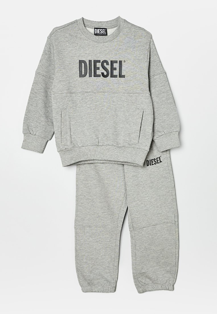 Conjunto de sudadera y pantalones de chándal grises, hecho de suave algodón, con un gran logo negro "DIESEL" en el pecho y en la pierna derecha. Puños acanalados.