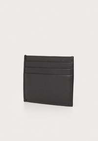 Porte-cartes en cuir noir avec quatre emplacements pour cartes, design épuré, texture lisse et détails de couture minimalistes. Forme rectangulaire.
