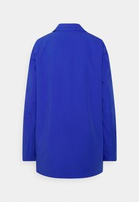 Chemise bleue à manches longues avec un col structuré, un tissu lisse et une coupe droite avec un ourlet arrondi. Design minimaliste, sans motifs.