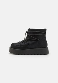 Bottines noires en tissu texturé, avec un bout rond, des lacets réglables et une semelle épaisse à plateforme avec un motif en zigzag.