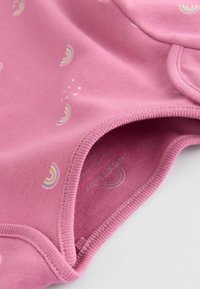 Bodysuit en coton rose avec de petits motifs de rainbow, doté d'un col rond et de fermetures à pression en bas. Texture lisse et couture.