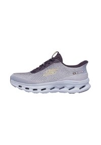 Zapatilla deportiva de malla gris claro con talón y lengüeta morados, que presenta una suela blanca gruesa con cámaras de aire y un logo dorado en el lateral.