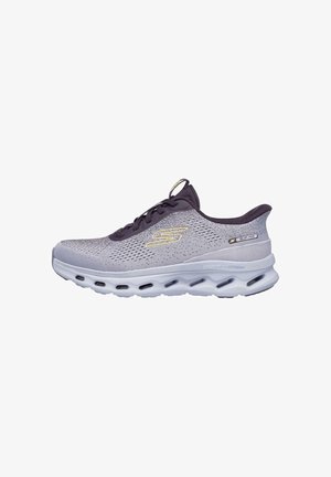 Zapatilla deportiva de malla gris claro con talón y lengüeta morados, que presenta una suela blanca gruesa con cámaras de aire y un logo dorado en el lateral.