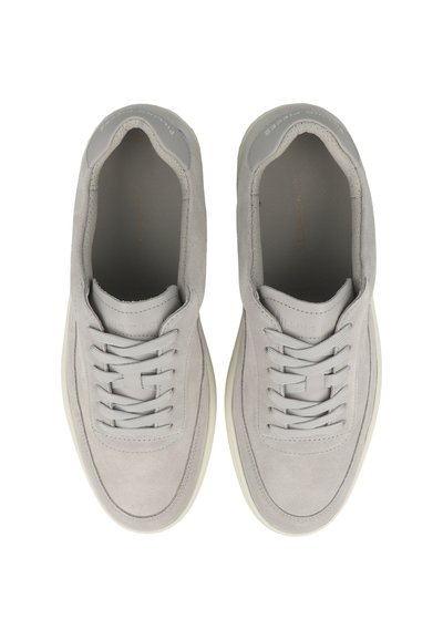 Paar hellgraue geschnürte Sneaker mit Wildleder-Obermaterial und weißen Gummisohlen, von oben auf weißem Hintergrund betrachtet.