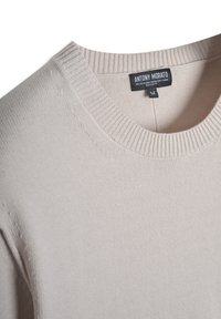 Maglione beige chiaro con collo rotondo e polsini a coste. Realizzato in un morbido miscuglio di viscosa. Presenta un'etichetta con il nome del marchio "ANTONY MORATO."