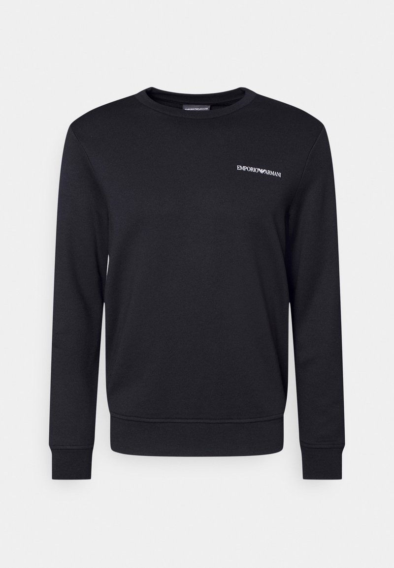 Černá mikina vyrobená z měkkého bavlněného materiálu, s kulatým výstřihem, dlouhými rukávy a malým bílým logem na hrudi.