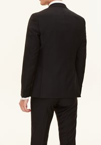 Svart skräddarsydd kavaj med insvängda slag, enkel slits, slim fit och knäppta ärmar. Slätt tyg med matt finish.