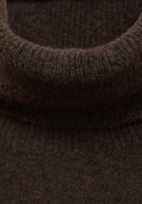 Bruine gebreide turtleneck trui met een geribbelde textuur en een zachte, fuzzy uitstraling, voorzien van een dikke, gevouwen kraag.