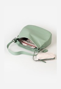 Borsa in pelle verde con una texture liscia, dotata di tracolla regolabile e di una piccola pochette coordinata. L'interno presenta una fodera di colore chiaro con tasche.