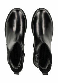 Par de botas de cuero negro brillantes hasta el tobillo con cremalleras laterales, punteras redondeadas y paneles de elastano texturizados, vistas desde arriba.