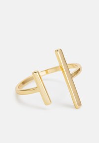 Zlatý prsteň s úzkym pásikom a dvoma predĺženými, paralelnými tyčkami rôznych dĺžok, hladko leštený, minimalistický dizajn.