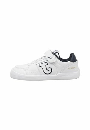 Zapatilla blanca infantil con forro interior negro, espiral decorativa negra en el lateral, cierre de velcro y texto dorado "ACADEMY" en el talón.