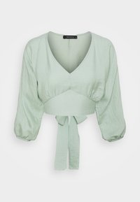 Lys grøn cropped bluse med V-hals, oppustede trekvartærmer og en frontbinding ved taljen.
