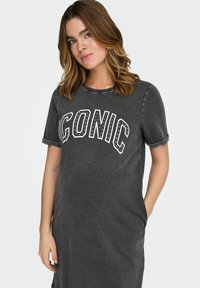 Halli T-särgi kleit lühikeste ülesrullitud varrukatega, millel on valgete tähtedega kirjaga "ICONIC" ning naelutatud aksendid. Vabaaja lõige taskutega.