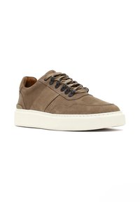 Zapatillas de ante marrón con superficie texturizada, que presentan cordones beige, ojales negros y una suela de goma blanca. Punta redondeada y collar acolchado.