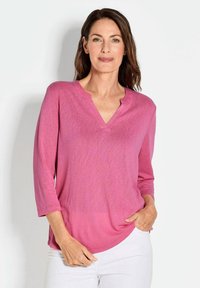 Rosa V-Ausschnitt Langarmtop aus leichtem Stoff, mit lockerer Passform und abgerundetem Saum. Schlichtes Design ohne sichtbare Muster oder Verzierungen.