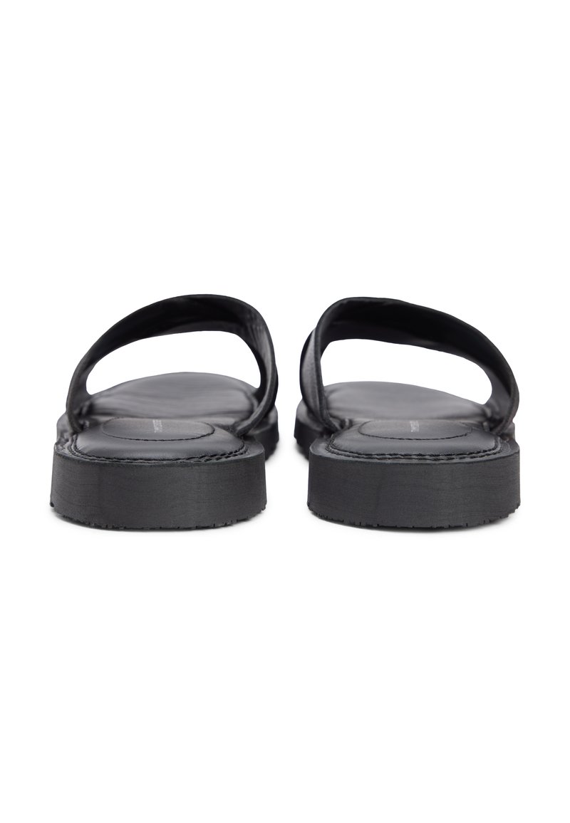 Sandalias negras de punta abierta con plantillas acolchadas y suelas gruesas, vistas desde atrás sobre un fondo blanco.