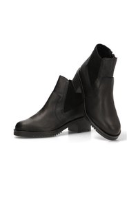 Botas de tobillo de cuero negro con textura suave, paneles elásticos laterales y tacón cuadrado. Destacan por su diseño minimalista y su suela duradera.