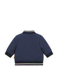 Giacca invernale blu navy con colletto e polsini a costine. Presenta un orlo a righe orizzontali e un design pulito e minimalista.