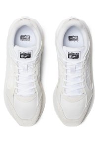 Weiße Sportschuhe aus Netz- und Wildledermaterialien, mit Schnürdesign, Logo-Tags und strukturierten Akzenten an den Seiten und der Zehenkappe.