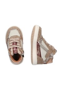 Beige hoge sneakers met geperforeerde textuur, glanzende zilveren accenten, een witte leren paneel en een zijrits. Klittenbandsluiting.
