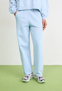 Pantalons de jogging bleu clair en tissu doux mélangé coton, dotés d'une taille élastique avec cordon de serrage, de poches latérales et d'une coupe décontractée.
