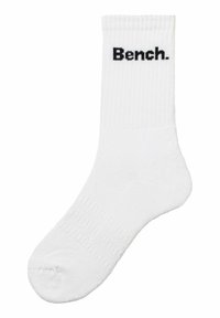 Weiße Crew-Socke mit gerippter Struktur und schwarzem "Bench."-Logo, das oben aufgedruckt ist. Weiches Material und standardmäßige Socke-Form.