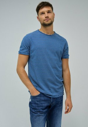 T-shirt rayé bleu avec des manches courtes et un col rond. En coton, coupe décontractée, associé à un jean bleu déchiré.