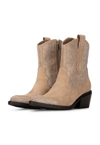 Botines de ante beige con un diseño estampado, adornos de tachuelas plateadas y un tacón negro. Cuenta con una cremallera lateral para facilitar su uso.