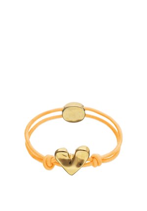 Coletero elástico amarillo con dos adornos redondos de metal dorado, uno con forma de corazón estilizado, anudados a cada lado.