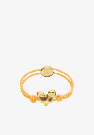 Coletero elástico amarillo con dos adornos redondos de metal dorado, uno con forma de corazón estilizado, anudados a cada lado.