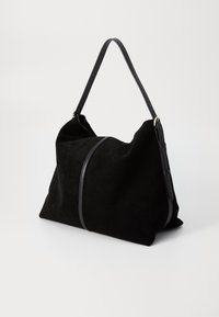 Zwarte suède schoudertas met een zachte, slungelige vorm. Voorzien van een leren schouderband en een contrasterende leren naaddetail. Geen extra hardware.
