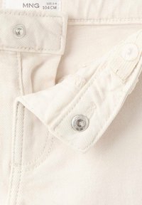 Denim tkanina kremne barve z ribjo kostjo teksturo, z kovinskimi sponkami z zatiči in šivi v bližini pasu.