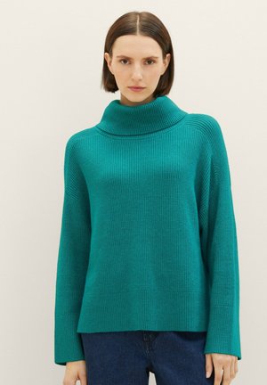 Teal ribbed sweater with a high cowl neck, loose-fit long sleeves, and a straight hem, made from a soft knit fabric.