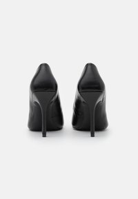 Svarta läderhögklackade skor med spetsig tå och smal klack, slät textur och minimalistisk design.