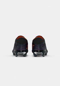 Black and purple soccer cleats with a textured upper, orange accents, and a transparent rubber sole. Rear view shows a streamlined design.