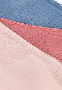 Tessuti in rosa chiaro, corallo e blu con un motivo testurizzato e una delicata bordatura in pizzo lungo i bordi.