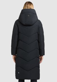 Zwarte pufferjas met een chevronpatroon, voorzien van een grote capuchon, knoopsluiting en zijzakken. Gladde textuur en ontwerp tot op de knie.