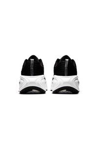 Scarpe da atletica nere con una tomaia testurizzata, suola intermedia bianca e suola esterna nera. Presentano un design elegante e accenti minimalisti.