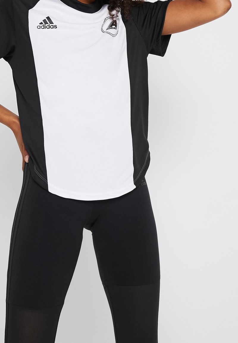 Černo-bílý atletický dres s krátkými rukávy, na levé hrudi s logem Adidas a s kontrastními bočními panely.