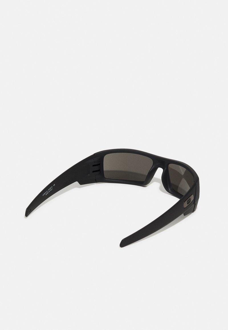 Gafas de sol negras con un acabado mate elegante, lentes rectangulares y varillas curvadas. Presentan un sutil acento cerca de la bisagra, que proporciona durabilidad.