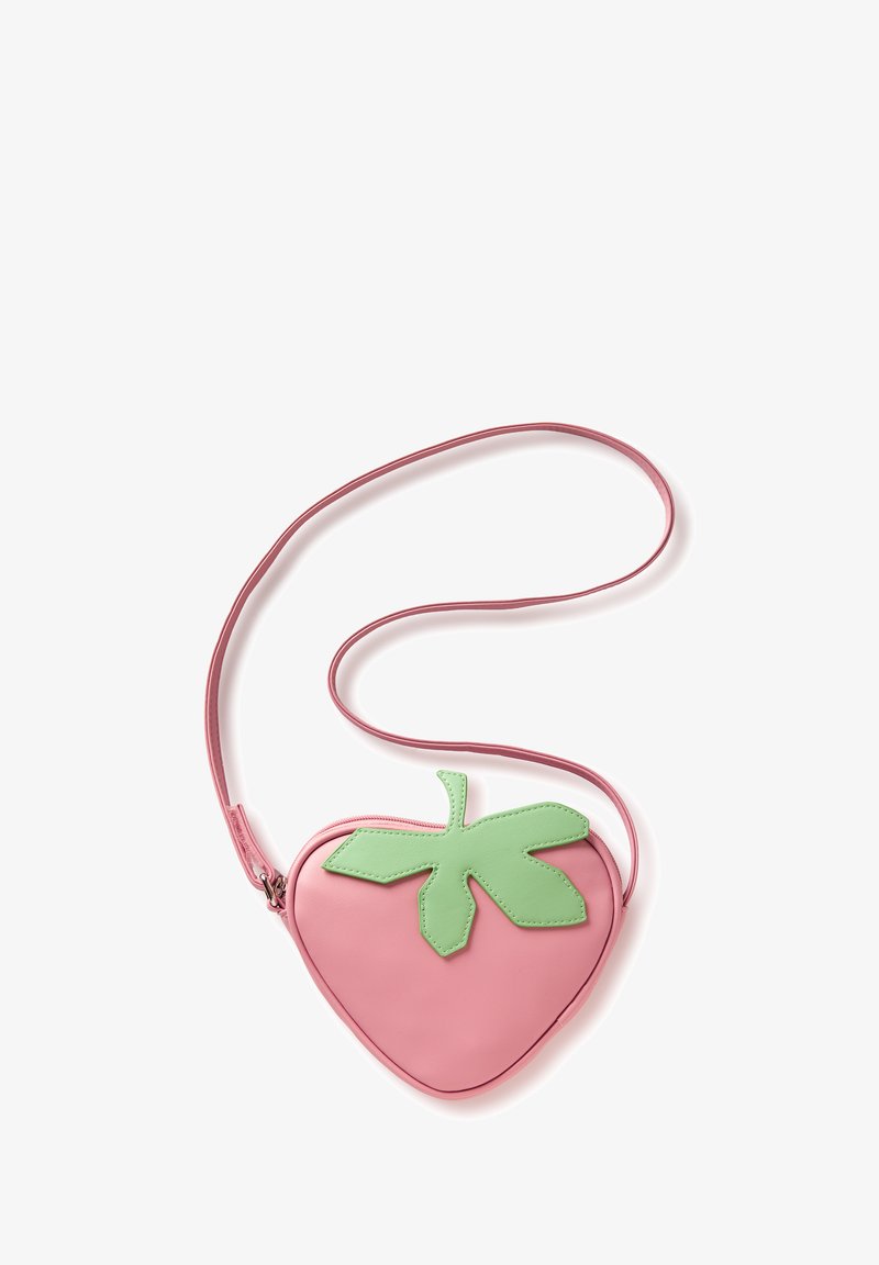 Bolso bandolera rosa en forma de corazón con detalle de hoja verde y correa larga sobre fondo blanco.