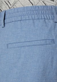 Svetlemodré látkové šortky s elastickým pasem, se jednou zadní kapsou a hladkým, strukturovaným povrchem.