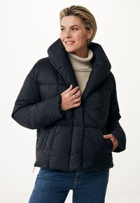Doudoune noire avec un large col, design matelassé, poches avant et coupe courte, portée sur un pull à col roulé beige.