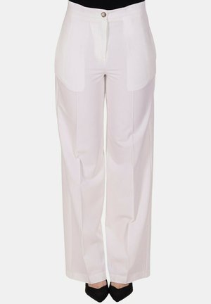 Pantaloni bianchi a vita alta e gamba larga con tasche frontali e chiusura con bottoni, indossati con scarpe nere appuntite.