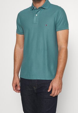 Zielona koszulka polo wykonana z bawełny, z klasycznym kołnierzykiem, krótkimi rękawami, zapięciem na dwa guziki i małym logo na piersi.